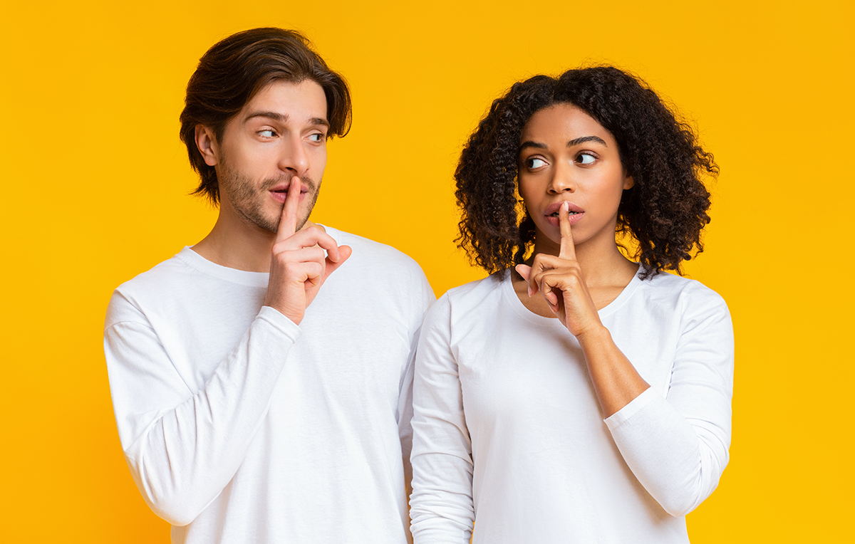 Das Bild zeigt einen Mann und eine Frau auf einem gelben Hintergrund. Beide halten den Zeigefinger vor ihren Mund.